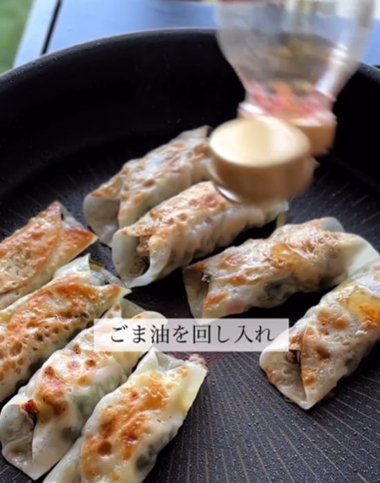 餃子にごま油をまわしかけている様子