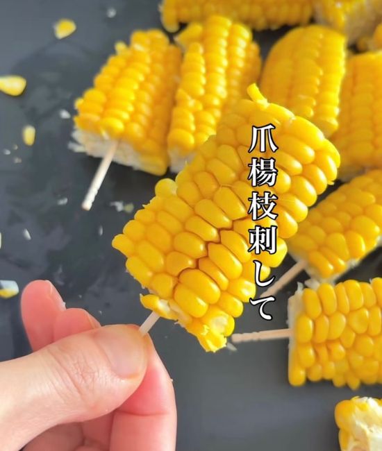 爪楊枝が刺さったトウモロコシ