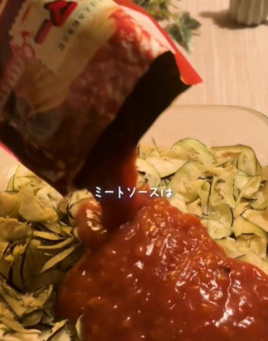 ナスの上にミートソースをかけている様子
