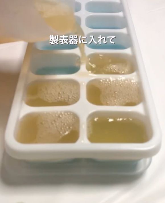 製氷皿にシェイカーのグレープフルーツジュースを注ぐ様子