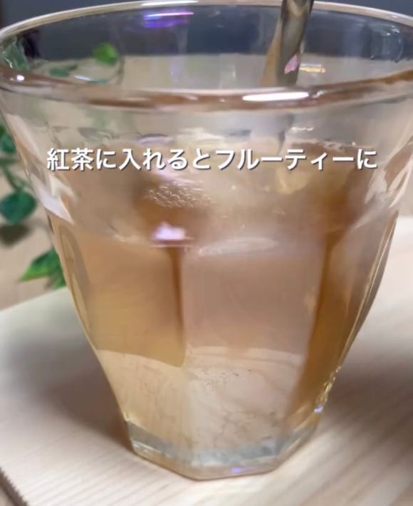 凍らせたグレープフルーツジュースのキューブをグラスに入れて紅茶を注ぐ様子