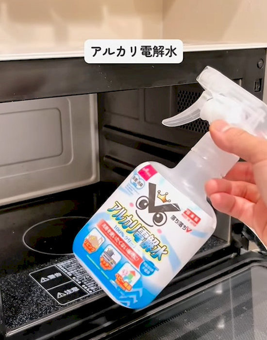 アルカリ電解水のスプレーボトルを持つ人