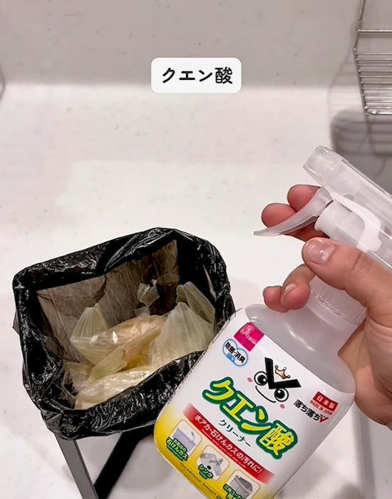 クエン酸スプレーのボトルを持つ人