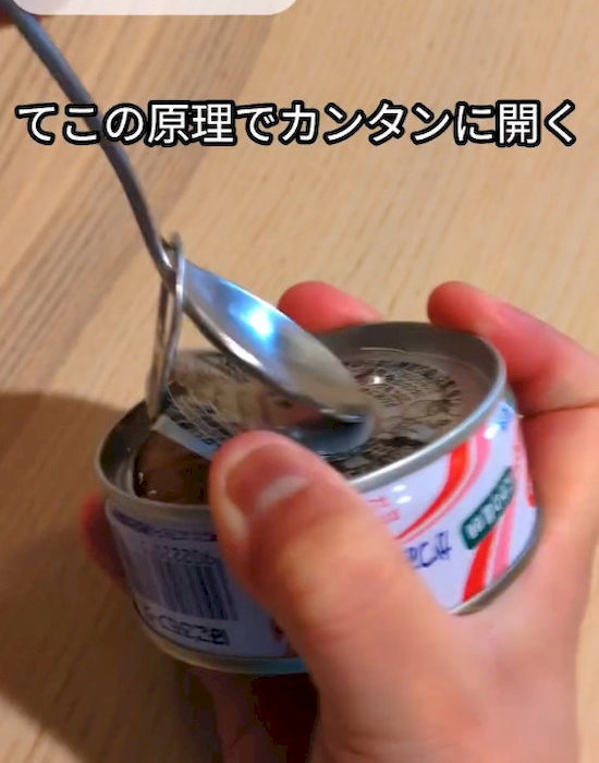 スプーンで缶詰を開けている様子