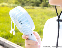 携帯扇風機を使う女性の写真