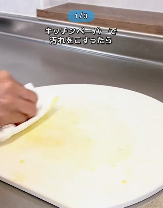 キッチンペーパーと油でまな板をきれいにしている様子
