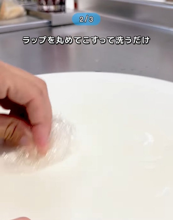 丸めたラップでまな板をこすっている様子