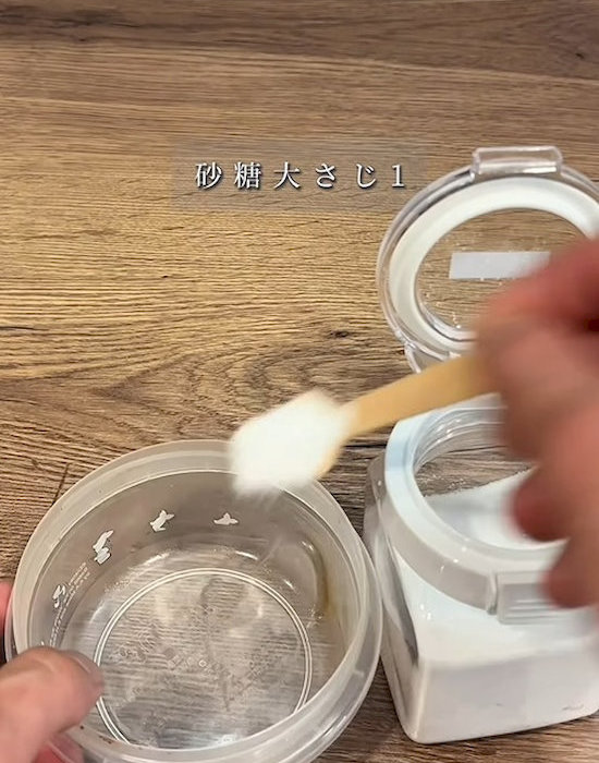 プラスチック製保存容器に砂糖を入れる様子