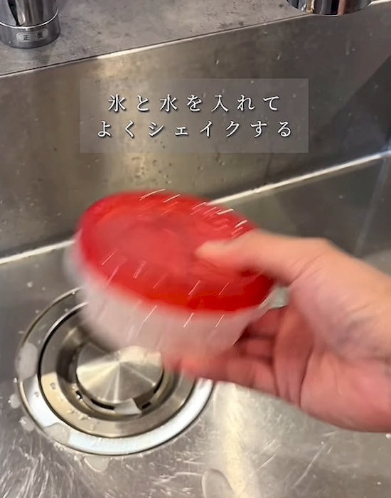 蓋をしたプラスチック製保存容器を振る様子