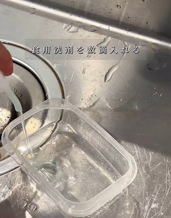 水を入れたプラスチック製保存容器に食器用洗剤を入れる様子