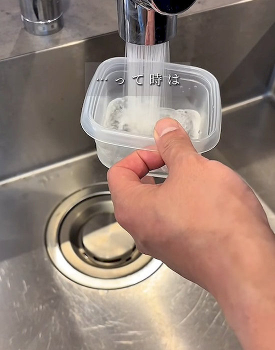 プラスチック製保存容器に水を入れる様子