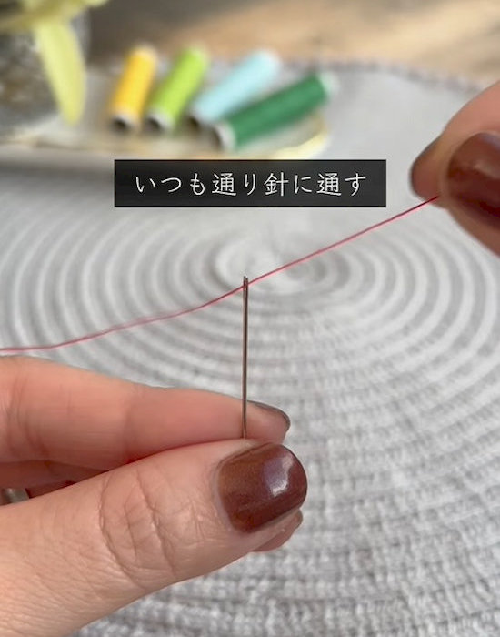 針に糸を通している様子