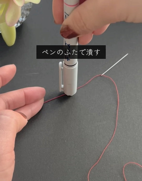 ペンで糸をつぶしている様子