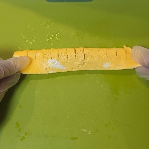 切れ目を入れた薄焼き卵を半分に折った様子