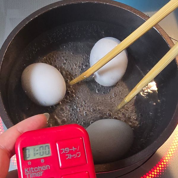 鍋に卵を入れて菜箸で回す様子