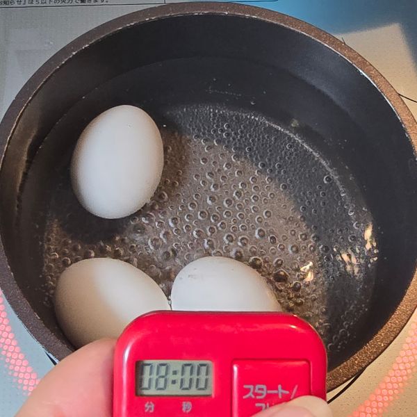 鍋に卵を入れてストップウォッチで時間を計る様子