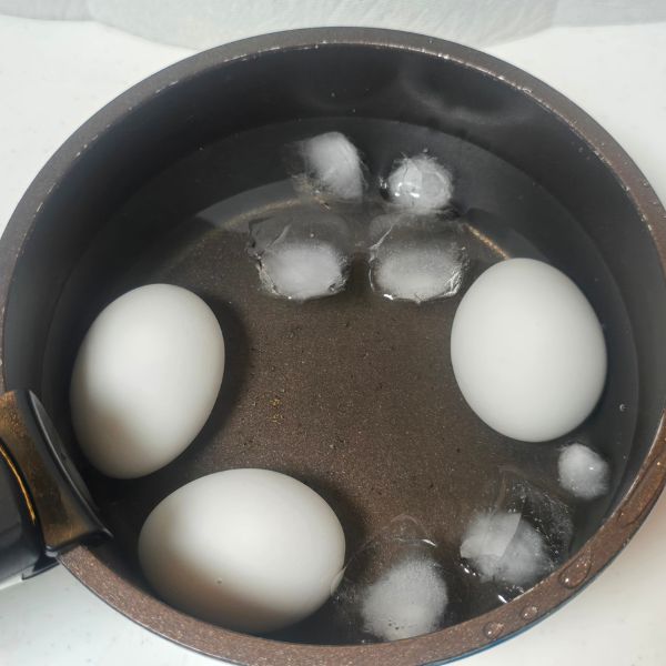 ゆで卵を氷を入れた水で冷やす様子