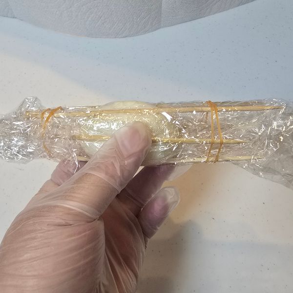ゆで卵をラップで包んで両端を輪ゴムで固定した様子