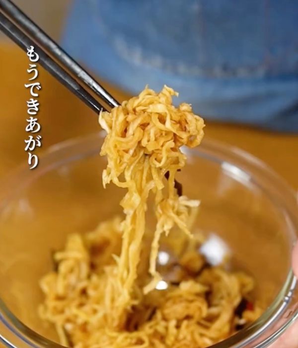 完成した『切り干し大根のはりはり漬け』を箸で持ち上げる様子