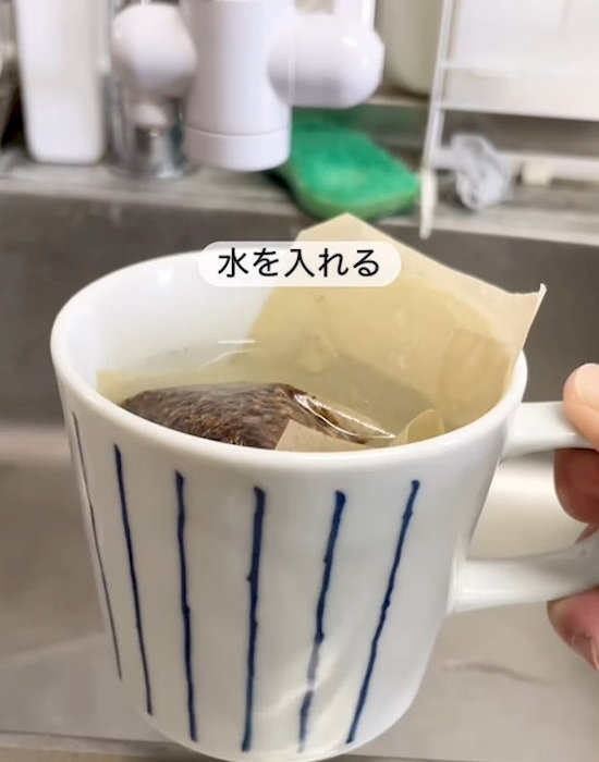 麦茶のパックが入ったカップに水を入れている様子