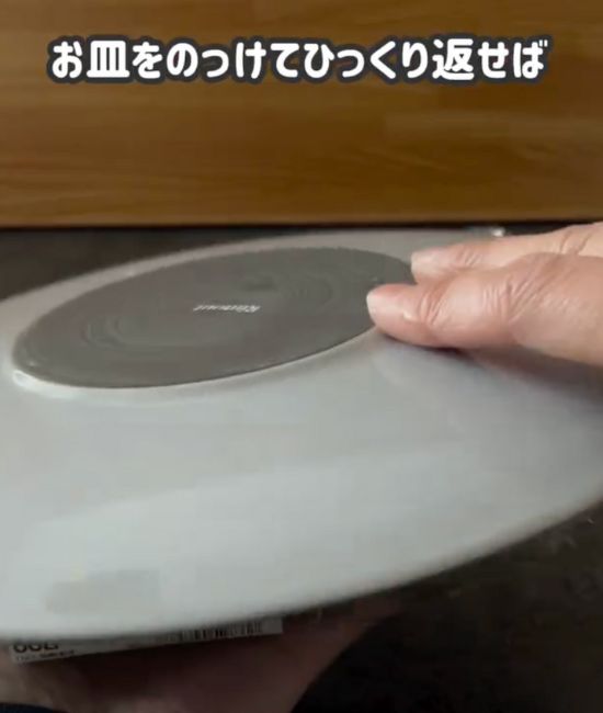 裏返しの状態で入っている刺身の入ったトレーのふた部分に皿をのせた様子