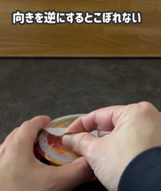 ゼリーのフィルムのつまみを奥側に向けてフィルムを開ける様子