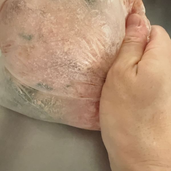 豚ミンチと調味料を入れたポリ袋を袋の外側からもむ様子