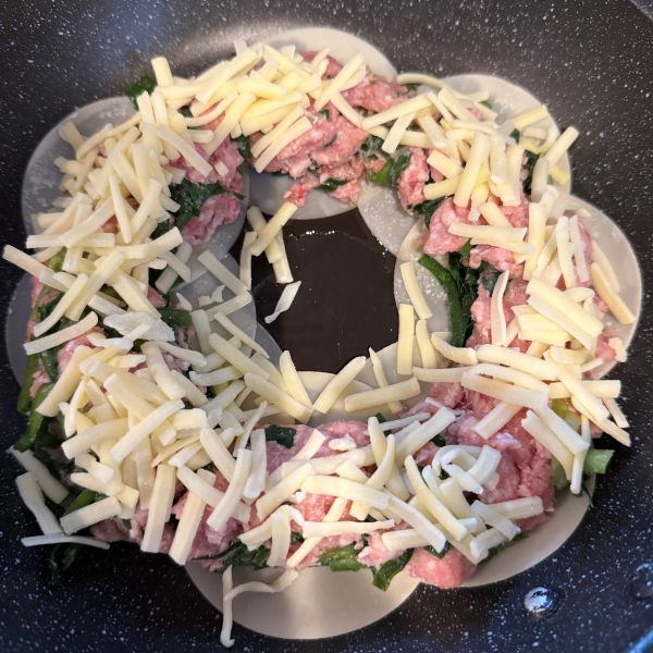 餃子のタネの上にとろけるチーズをドーナツ状にのせた様子