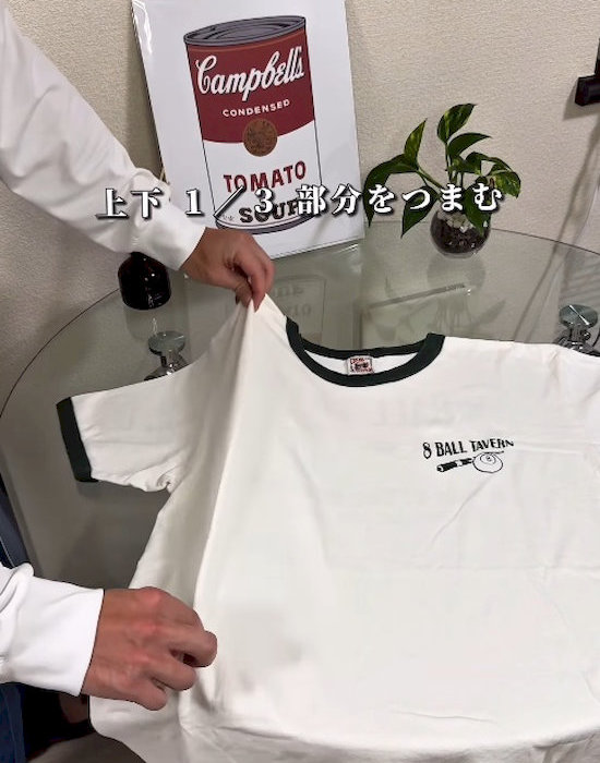 肩口と裾近くをつまむ