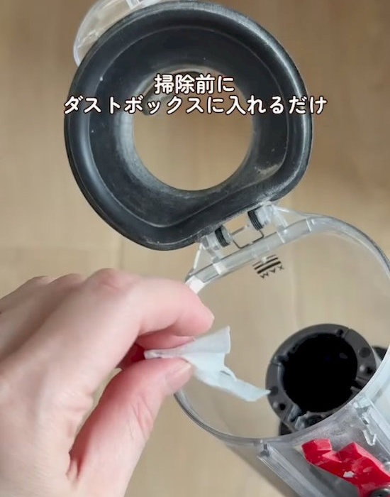小さくカットしたフローリングシートを掃除機のダストカップに入れている様子
