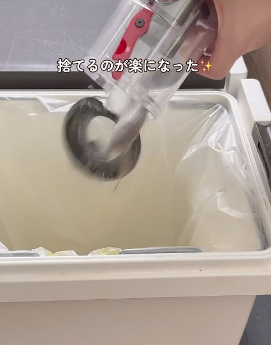 掃除機のダストカップからゴミを捨てている様子