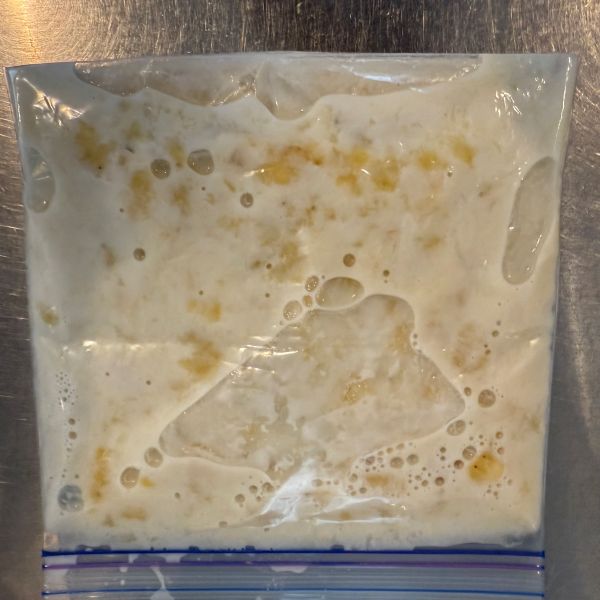 つぶしたバナナと牛乳を入れたチャック付き保存袋の空気を抜いて密閉した様子
