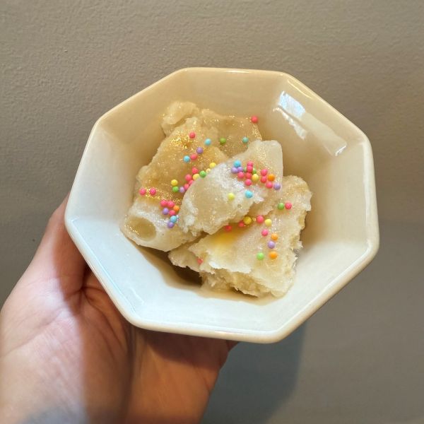 お皿に盛り付けたバナナと牛乳で作ったアイスクリームにトッピングをのせた様子