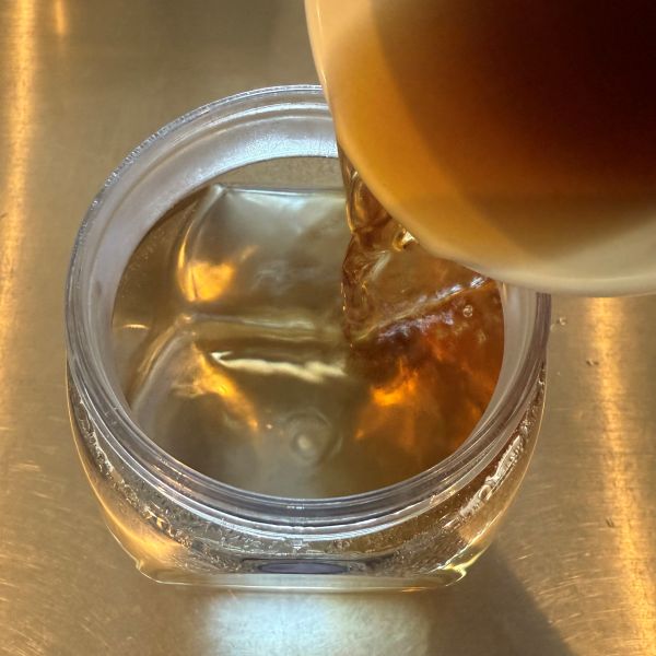 水を入れたポットにマグカップに作った麦茶を入れる様子