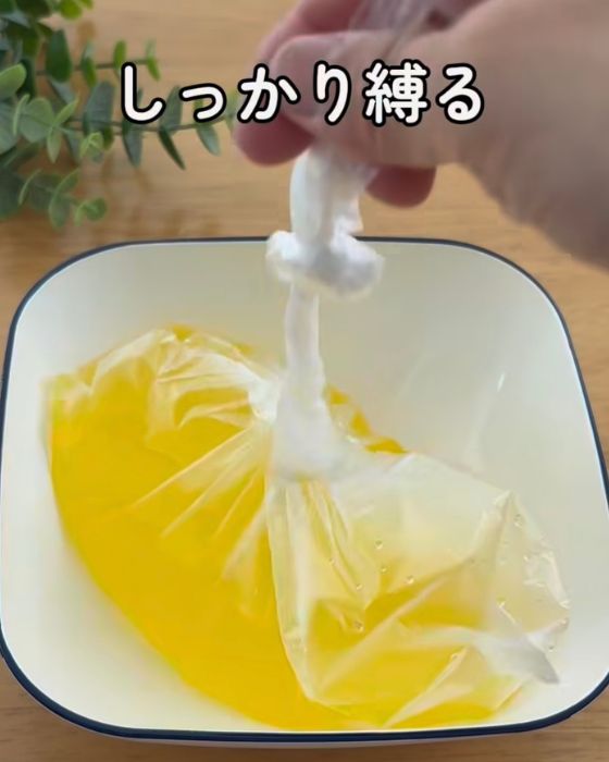 ジュースを入れたポリ袋の口をしっかり縛った様子