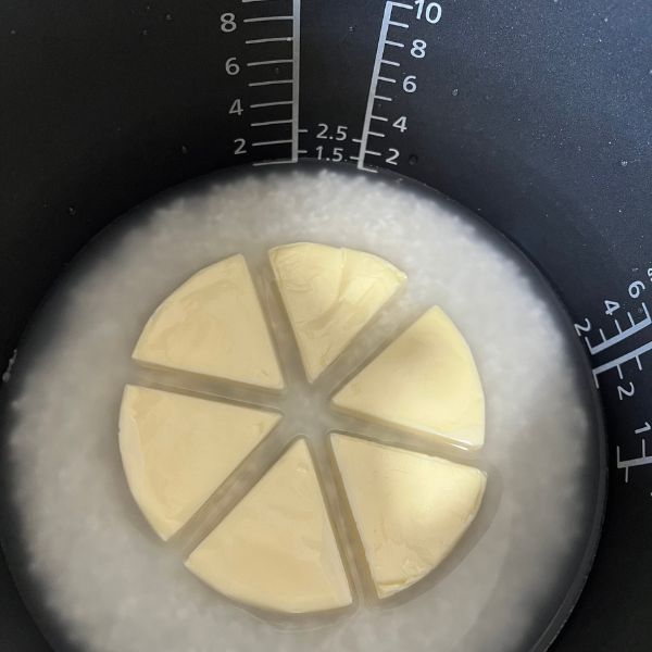 お米と水の入った内釜にチーズを並べて置いた様子
