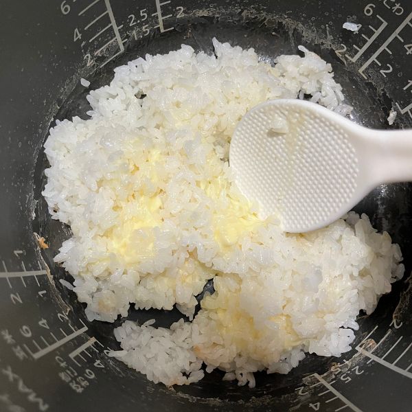 ご飯とチーズをしゃもじで混ぜ合わせる様子