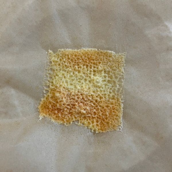 クッキングシートの上にスライスチーズをのせて加熱した様子