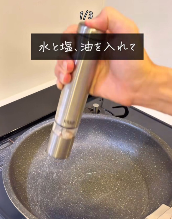 お湯が入ったフライパンに塩を入れている様子
