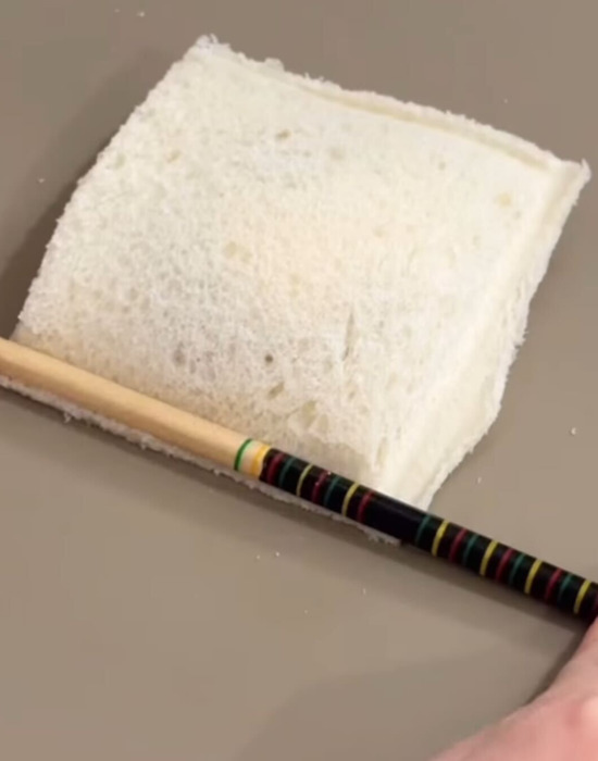 食パンの端を箸で押さえ付けている様子