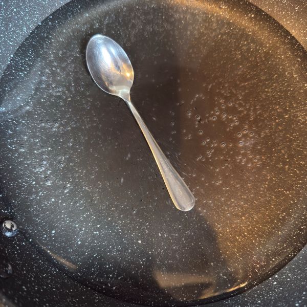 水を入れたフライパンにスプーンを沈めた様子