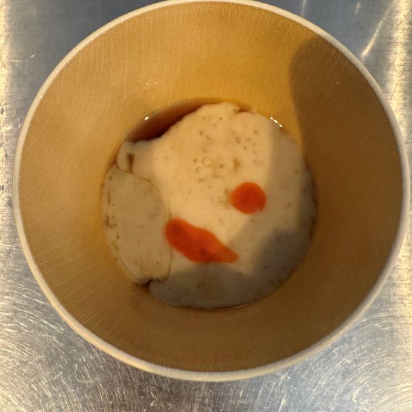 めんつゆとごまだれを入れた器にラー油を入れた様子