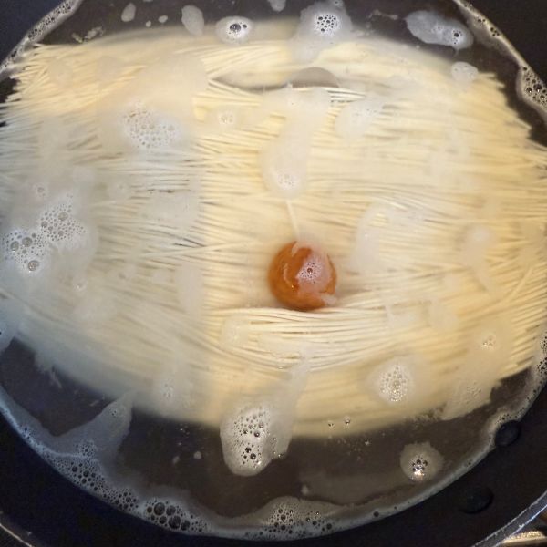梅干しを入れてそうめんをゆでている様子