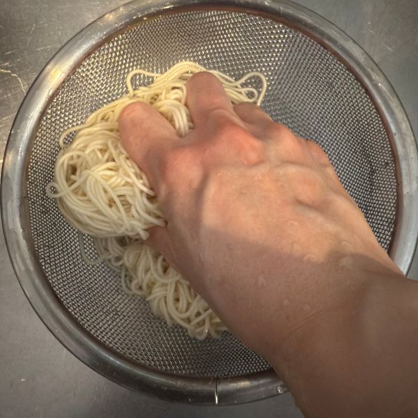 ザルにあげたそうめんをつかむ様子