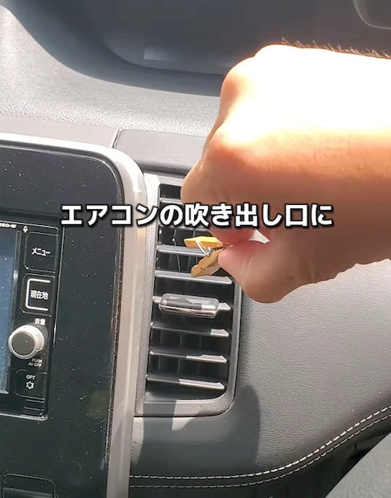 エアコンの吹き出し口に木のクリップを挟む様子