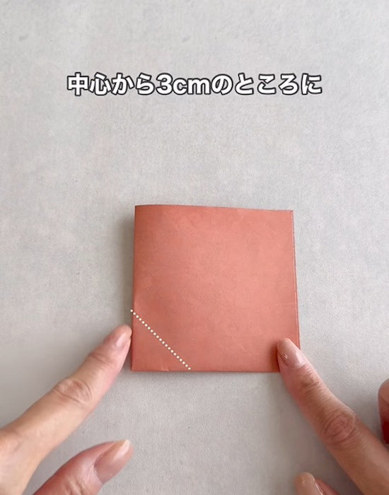 折った折り紙を指さす様子