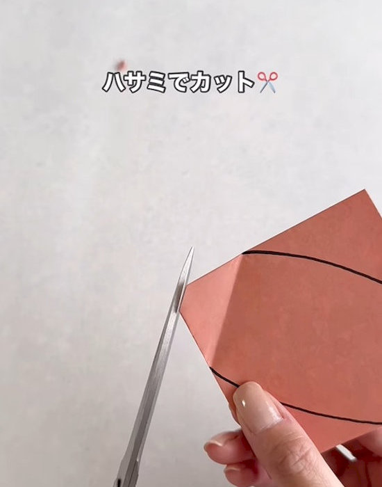 線を描いた折り紙を切る様子