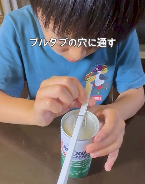 プルタブの穴に折ったレシートを通す様子