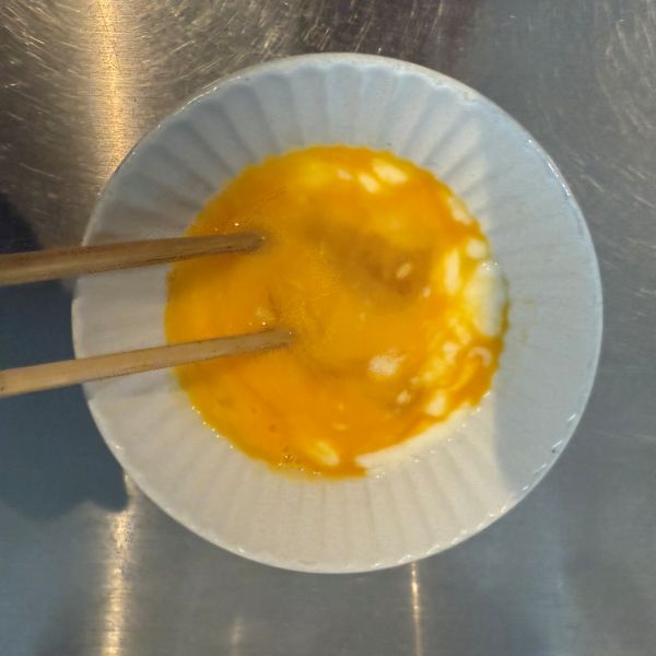 卵とヨーグルトを箸で混ぜ合わせる様子