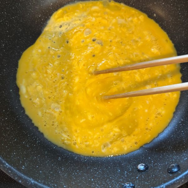フライパンでスクランブルエッグを作る様子
